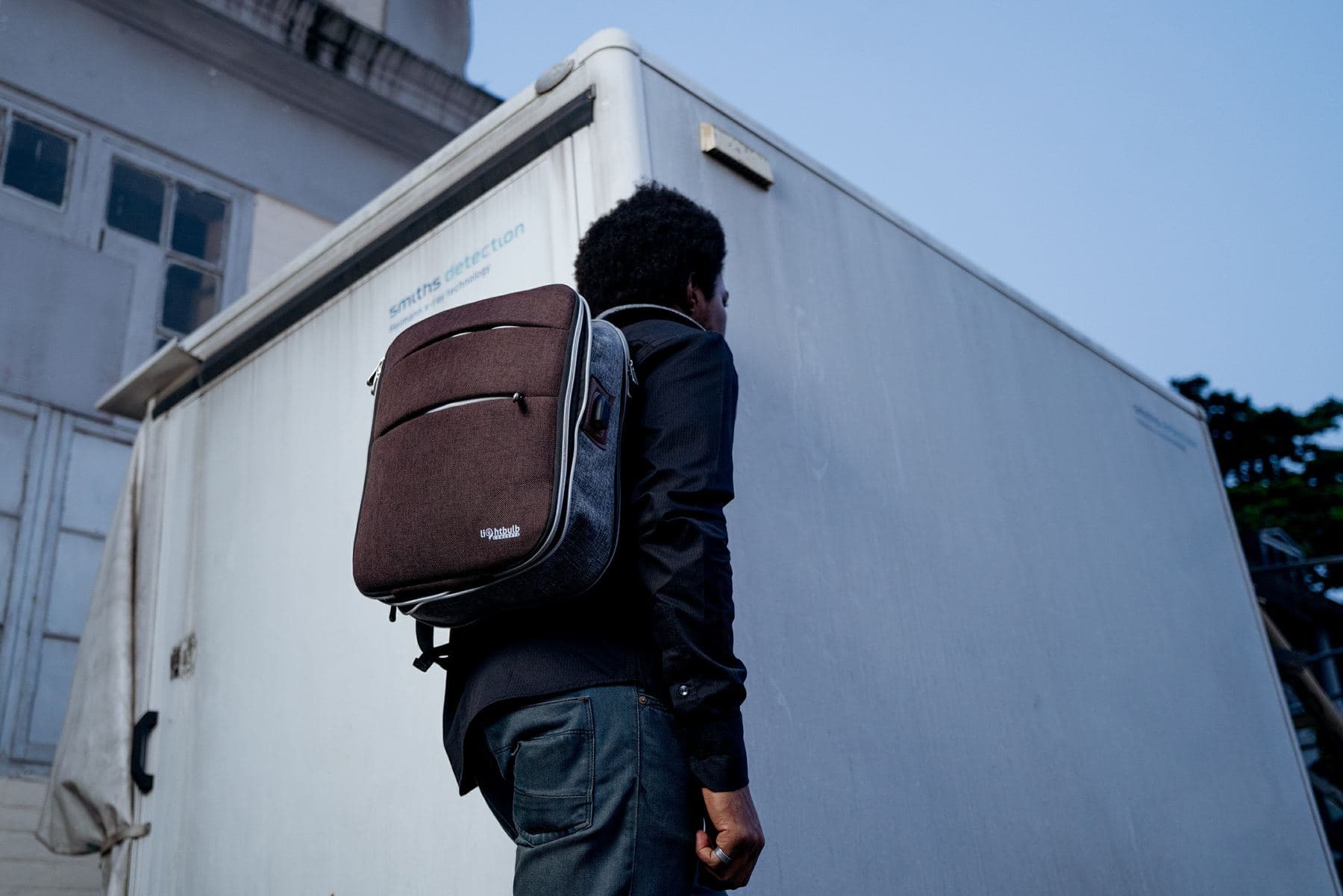 Brown heathered Lightbulb laptop backpack worn outdoors